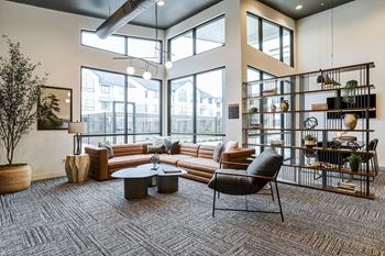 a living room with large windows and a couch and a table